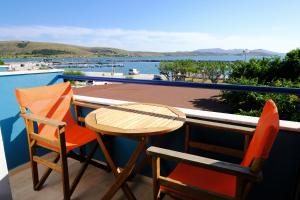 a table and chairs on a balcony with a view of the water at Galazio Limani - Rooms to let in Moúdhros