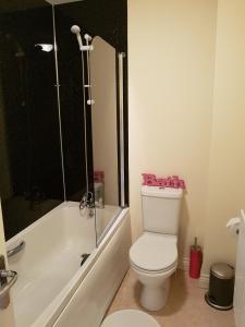 uma casa de banho com um WC, um chuveiro e uma banheira em Livingston 4 bedroom townhouse em Livingston