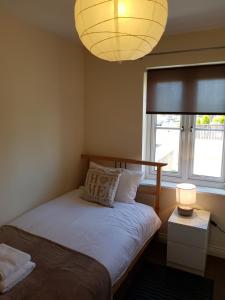 a bedroom with a bed with a lamp and a window at Livingston 4 bedroom townhouse in Livingston