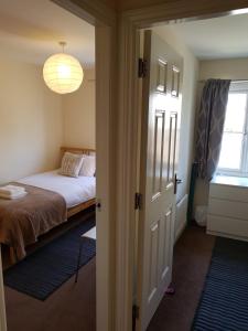 リビングストンにあるLivingston 4 bedroom townhouseのベッドルーム1室(ベッド1台付)、窓、ドアが備わります。