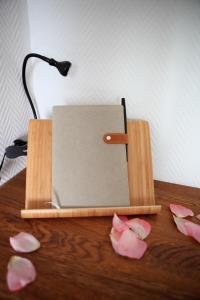 a book holder on a wooden table with pink flowers at Cabane l'hiver in Arcachon