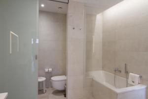 a bathroom with a tub and a toilet and a sink at ESTIMAR Calpe Suitopia in Calpe
