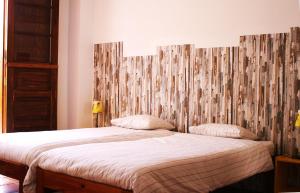 a bedroom with a bed with a wooden headboard at Casa Creativa in Hermigua