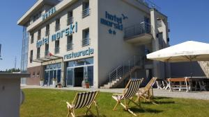 a group of chairs and an umbrella in front of a hotel at Hotel Morski in Gdynia
