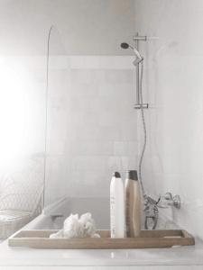 a bath tub with a shower with two bottles on it at ilab rural bed&breakfast in Navia