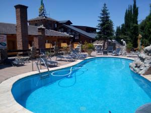 バサにあるHostal Sierra De Bazaの椅子と建物のある大きなプール