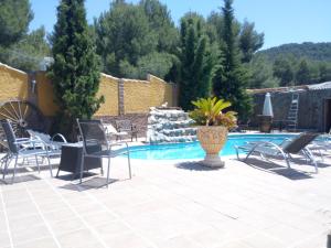 a patio with chairs and a swimming pool at Hostal Sierra De Baza in Baza