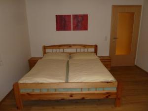 ドルフガシュタインにあるRainerhofの木製のベッドフレームが備わるベッドルームのベッド1台