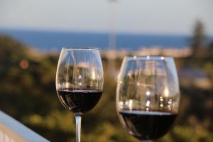 two glasses of red wine sitting next to each other at Home at Azores - City View Apartment in Ponta Delgada