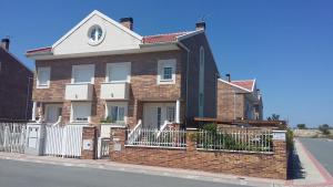 a brown brick house with a white roof at Chalet Villa Maria a 10 minutos de Puy du Fou in Burguillos de Toledo