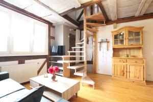 una sala de estar con una escalera de caracol y una mesa en Gîte Par ci, Par là en Turckheim