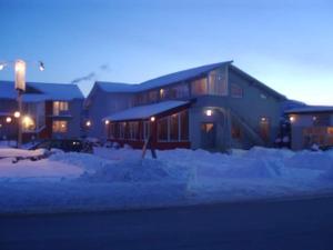 a building with snow in front of it at night at Pensiunea Evelyn in Gîrleni