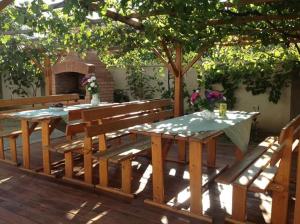 a wooden table and benches on a wooden deck at Pensiunea Evelyn in Gîrleni