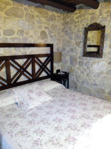 a bedroom with a bed in a stone wall at La caseta de Pedris in Valderrobres
