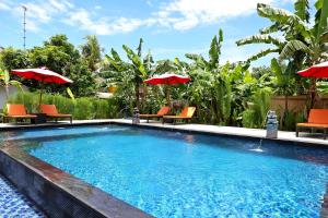 a swimming pool with orange chairs and umbrellas at Naradas Mushroom Beach in Nusa Lembongan
