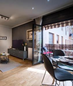 sala de estar con mesa, sillas y TV en Premium luxury city center apartment, en Madrid