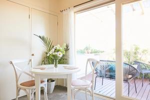 a white table with chairs and a vase of flowers on a balcony at The Potters Garden B&B in Rye