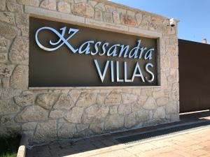 a sign for alexandria villas on a stone wall at Kassandra Villas in Hanioti