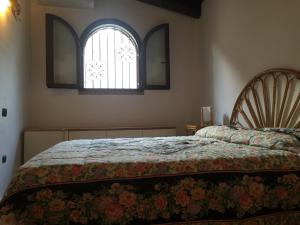 1 dormitorio con cama y ventana en Villa Adriana - Torre delle Stelle - mini appartamenti - Cagliari Villasimus Sardegna, en Torre delle Stelle