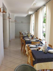 ミザーノ・アドリアーティコにあるHotel Lucianaの長いテーブルと椅子付きの長いダイニングルーム