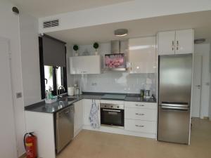 a kitchen with white cabinets and stainless steel appliances at Belvilla by OYO Casa del Ananas in San Pedro del Pinatar