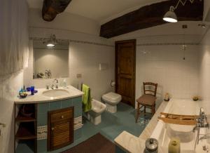 een badkamer met een bad, een wastafel en een toilet bij La Casa del Viaggiatore in Castiglion Fiorentino