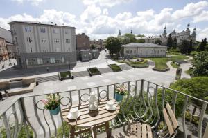 a balcony with a table and benches and a courtyard at Apartamenty Sienkiewicza - bezpłatny parking, centrum, park, fv in Kielce