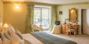 a bedroom with a bed and a mirror and a window at Crinan Hotel in Crinan