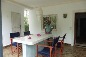 a man standing in a room with a table and chairs at Downtown Malindi Apartment in Malindi
