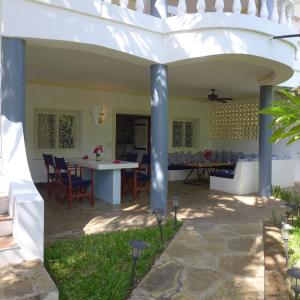 an outdoor patio with a white pergola at Downtown Malindi Apartment in Malindi