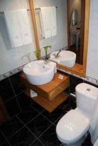 a bathroom with two sinks and a toilet and a mirror at Casa do Comendador in São Roque do Pico +31 photos