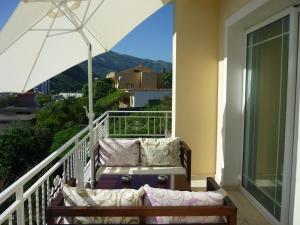 un balcón con 2 sofás y una sombrilla en Villa Basilika, en Vlorë