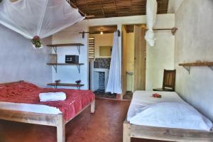 a bedroom with two beds and a fireplace at Ylang hôtel in Ambondrona