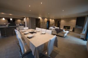 a dining room with a table and a living room at Gite De Charme Caussenard in Le Massegros