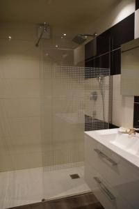 a bathroom with a glass shower and a sink at Gite De Charme Caussenard in Le Massegros