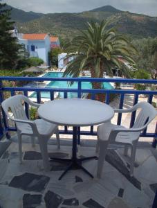 - Balcón con mesa blanca y 2 sillas en Hotel Sofia en Marathókampos