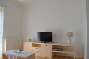 a living room with a tv on a wooden table at Apartmani Mila in Sukošan