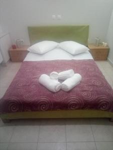 カラマタにあるKalamata Beach Maisonetteのベッドルーム1室(ベッド1台、タオル2枚付)