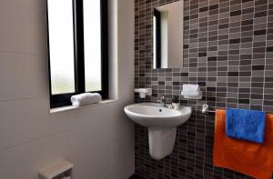a bathroom with a sink and a mirror at Sunset Haven Manikata - Walking distance to Golden Bay in Manikata