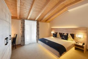 a hotel room with a large bed and a window at Hotel Cervo in Sils Maria