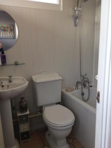 a white bathroom with a toilet and a sink at Coastal Cabin Chalet in Roch +41 photos