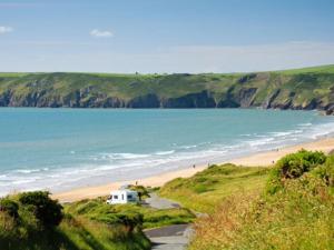 a view of a beach with a house and the ocean at Coastal Cabin Chalet in Roch