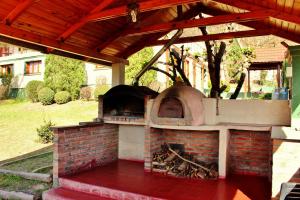 Reyes的住宿－Pura Vida Hosteria，室外砖炉,带木屋顶