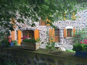 ConcisにあるFerme de la Micezelle près le Puy en Velayの花の前の石造りの家