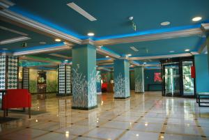 a lobby with blue ceilings and columns and a red chair at Hotel Ritual Torremolinos- Adults Only in Torremolinos +37 photos
