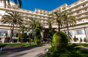 a building with palm trees in front of it at Intelier Orange in Benicàssim