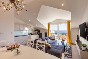 a kitchen and living room with a blue couch and a table at Apartments Solmar in Podstrana