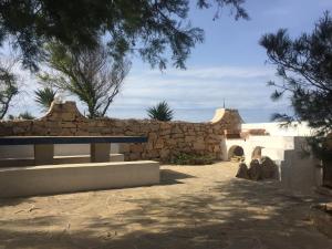 una panchina di fronte a un muro di pietra di Casa Tortuca a Lampedusa