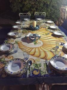 - une table avec des assiettes et des ustensiles dans l'établissement Casa Tortuca, à Lampedusa