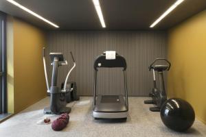 a gym with several exercise equipment in a room at Okko Hotels Paris Porte De Versailles in Paris